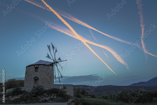 Windmills in Chios Island with airplane trails at the background