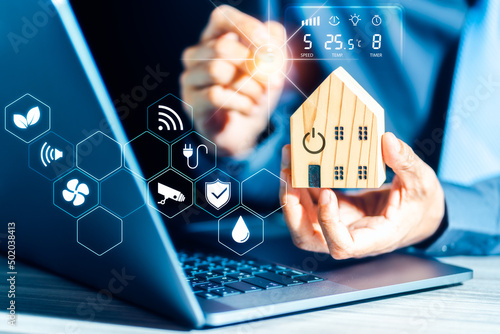 Businessman holding the home model with smart home automation icons around
