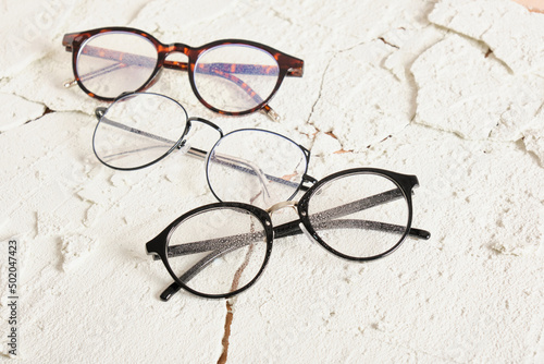 three stylish modern eye glasses on cracked background