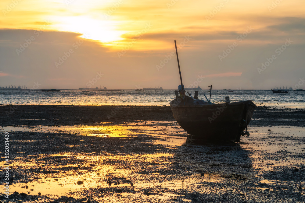 Wooden fishing boat on shore at sunset, Chonburi