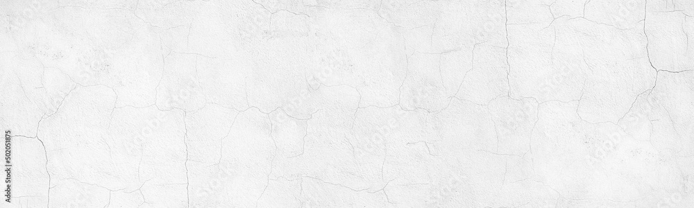Whitewashed old cracked concrete wall wide panoramic texture. White painted plaster surface with thin cracks. Light gray abstract grunge background