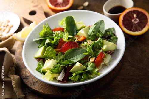 Healthy green salad with avocado and bloody orange