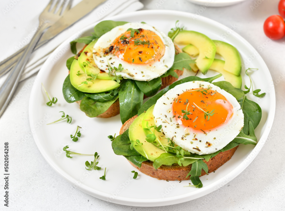 Bread with fried eggs, avocado and greens Bread with fried eggs, avocado and greens