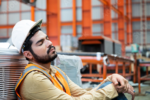 Fotografía Engineer of industrial working taking a nap or fall asleep inside of factory industrial area because of long working shift