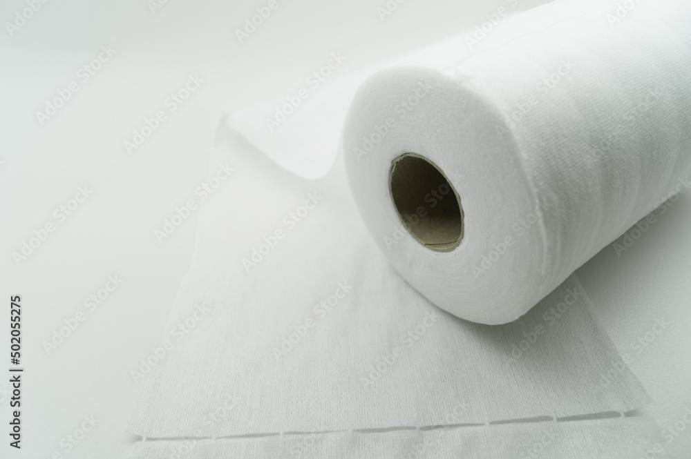 Fototapeta premium Universal white fabric napkins for cleaning in a roll. Bobbin with napkins for dispenser. Selective focus