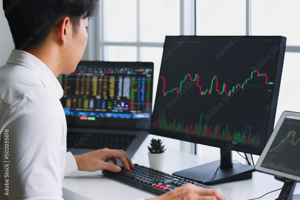 Young Asian investor watching the change of stock market on computer laptop screen. Young Asian investor watching the change of stock market on computer laptop screen.