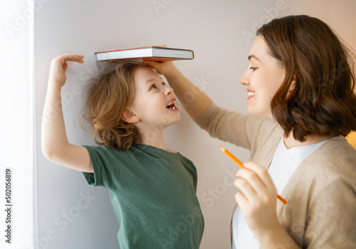 Obraz na plátně Kid and mother are measuring the growth
