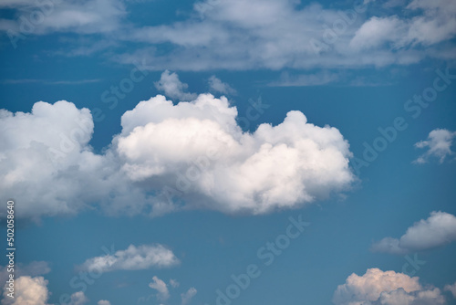 Bright landscape of white puffy cumulus clouds on blue clear sky