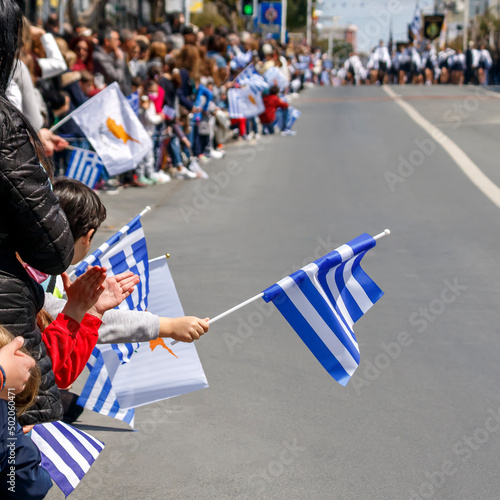 Billede på lærred Greek Independence Day parade spectators with Greek and Cypriot flags, Limassol,