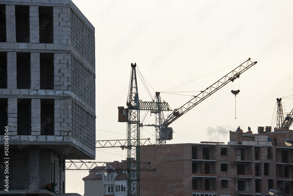 Tower cranes at high residential apartment buildings construction site. Real estate development