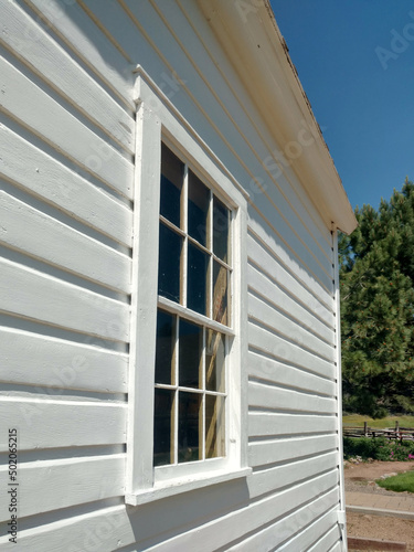 white house window wall wooden siding board wood painted slant exterior vintage home © DrewTraveler