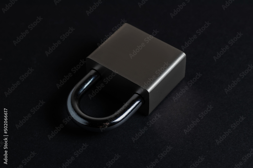 Steel padlock on the black textured background Steel padlock on the black textured background