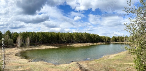 Lake in a forest in early spring day, panoramic view 