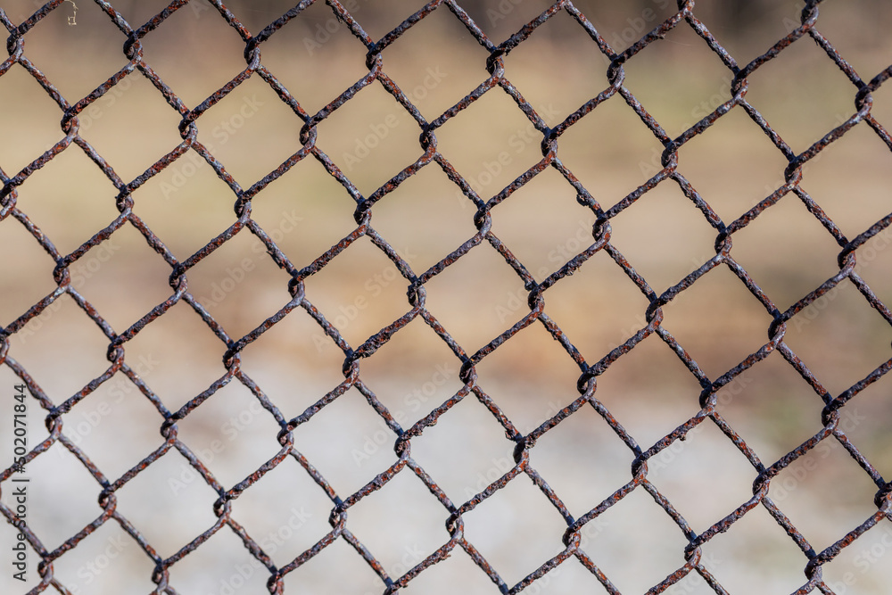 Metal mesh with traces of corrosion close-up on a natural background. Abstract background with repeating elements. Metal mesh with traces of corrosion close-up on a natural background. Abstract background with repeating elements.
