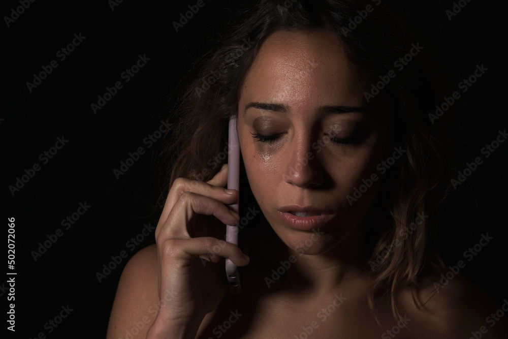 Female victim of domestic abuse phoning support group. Calling for help.