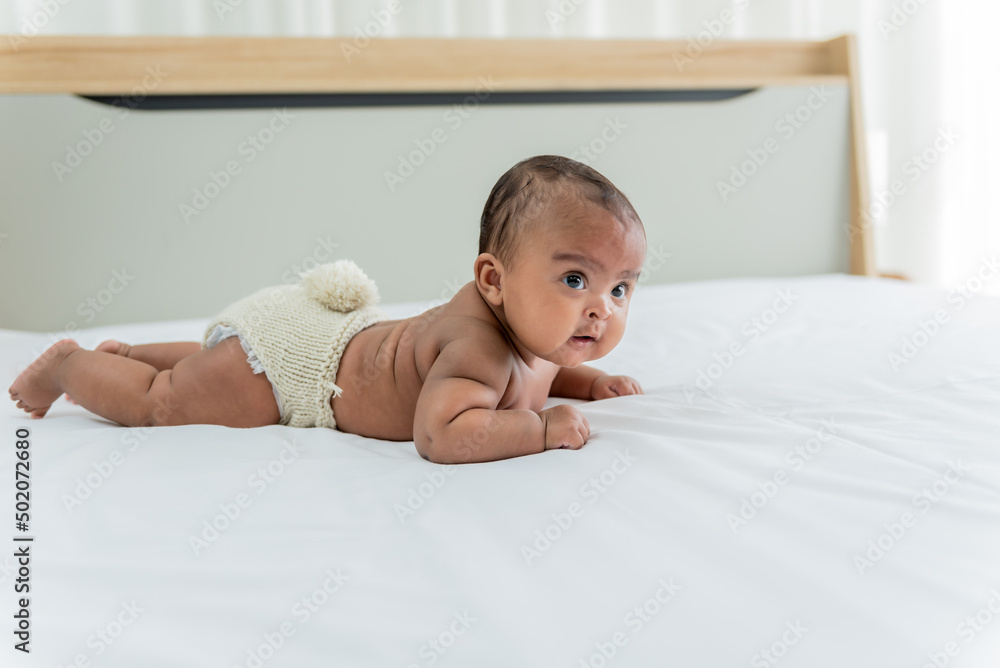 Portrait images of African baby newborn girl is 3 month year old, Lying prone on white bed in bedroom, to African newborn concept. Portrait images of African baby newborn girl is 3 month year old, Lying prone on white bed in bedroom, to African newborn concept.
