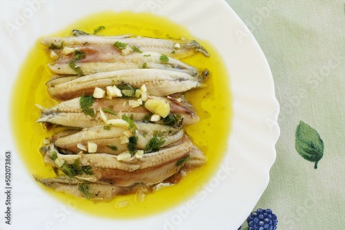 Cooked anchovy fish in vinegar with garlic, parsley and olive oil Spanish food. photo top view photo