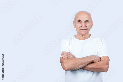 Portrait of old hairless serious man with crossed arms isolated on white background in studio