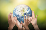 Earth globe in family hands. World environment day. Elements of this image furnished by NASA