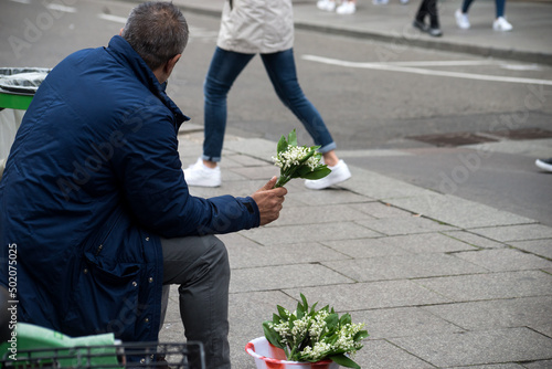 Portrait on back view of romanian man selling lilly of the valey flowers in the street photo