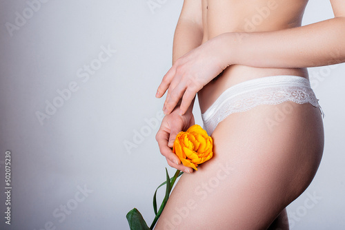 girl in white lingerie with a flower on a white background. women's health idea