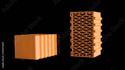 Two new perforated red bricks placed on black stand, building and construction materials concept. Stock footage. Bricks moving on black background.
