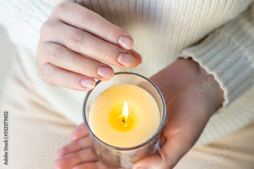 Heat from a candle on a woman's palm. photo