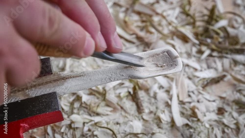 Filmmaterial von einem Holzlöffel schnitzen mit Schnitzmesser auf einer Werkbank mit Holzspäne, Deutschland photo