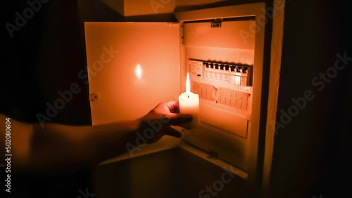 Filmmaterial mit Ton eines Sicherungskasten mit Sicherungen wird von einem Mann während eines Stromausfall mit brennender Kerze beleuchtet und geöffnet, Deutschland