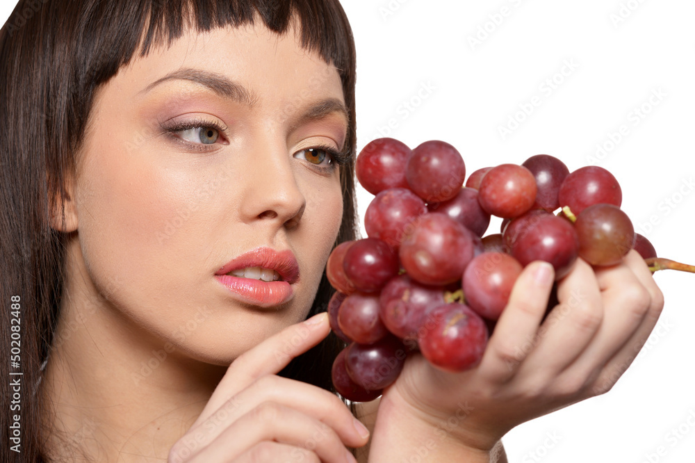 Portrait of young woman posing with grapes on white background Portrait of young woman posing with grapes on white background