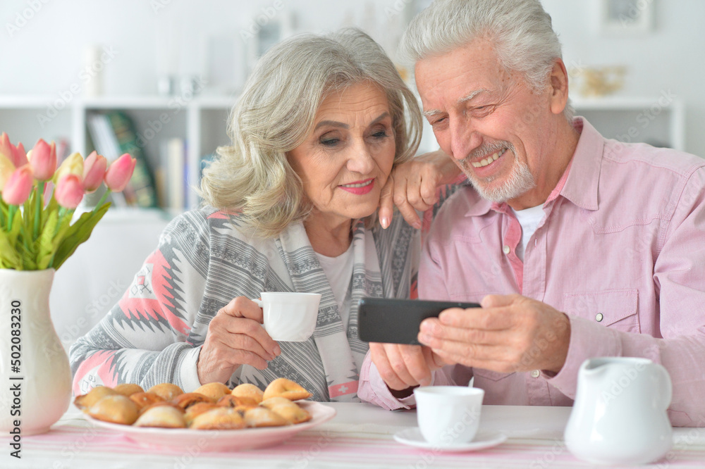 Portrait of happy senior couple with smartphone drinking tea Portrait of happy senior couple with smartphone drinking tea