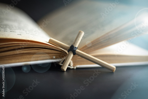 Homemade cross on an open Holy Bible book. Cross in open Bible.