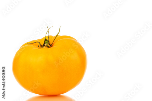 One ripe yellow tomato, close-up, isolated on a white background.