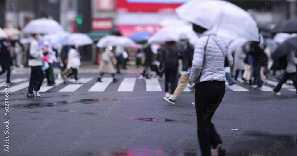 A slow motion of walking people at the crossing in Shibuya rainy day A slow motion of walking people at the crossing in Shibuya rainy day