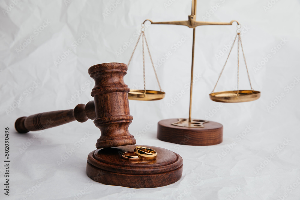 Wooden gavel with rings and scales. Family and law concept Wooden gavel with rings and scales. Family and law concept