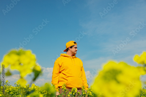 ukrainian man in rapeseed field in spring time