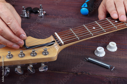 Guitar master adjusts trussrod on electric guitar.