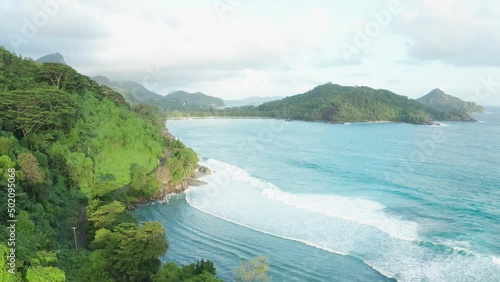 Aerial dolly tilt up over the coast overlooking Port Launay bay, Mahe