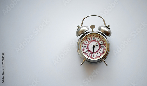 An old mechanical alarm clock with an iron bell on a white isolate.The alarm clock is a clean place for text. Reminder with a call.