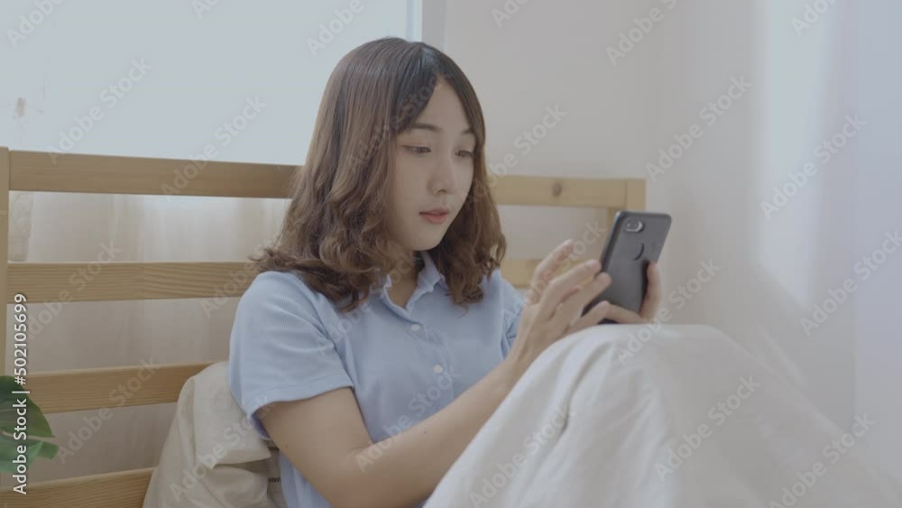 Holiday concept of 4k Resolution. Asian girls playing cell phones in the bedroom. Holiday concept of 4k Resolution. Asian girls playing cell phones in the bedroom.