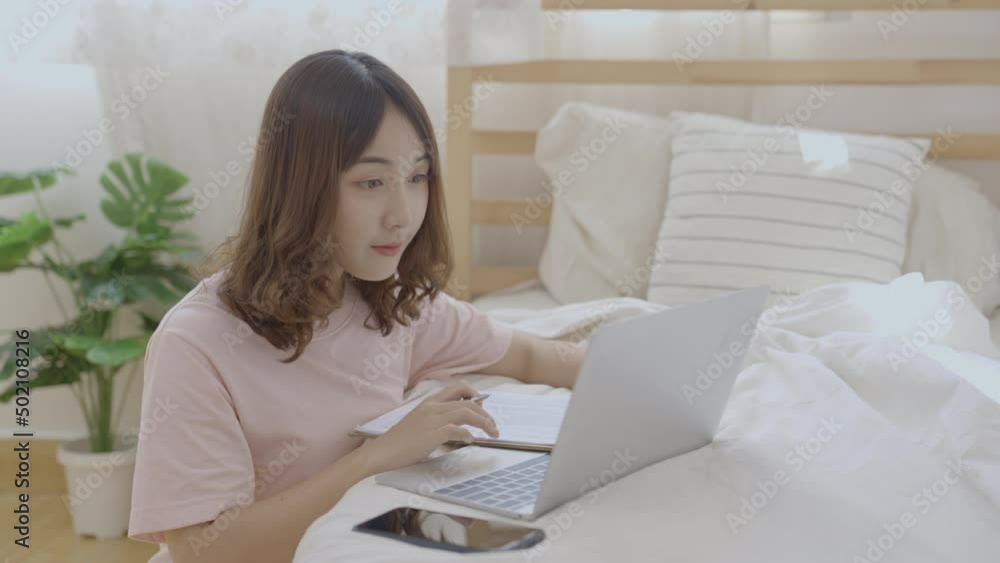 Holiday concept of 4k Resolution. Asian girls working with computers in the bedroom. Holiday concept of 4k Resolution. Asian girls working with computers in the bedroom.