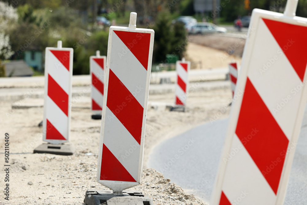 Słupki ostrzegawcze na budowie nowej drogi w mieście.  - obrazy, fototapety, plakaty 