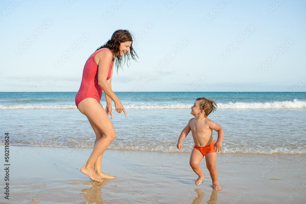 mother and son having fun on the beach