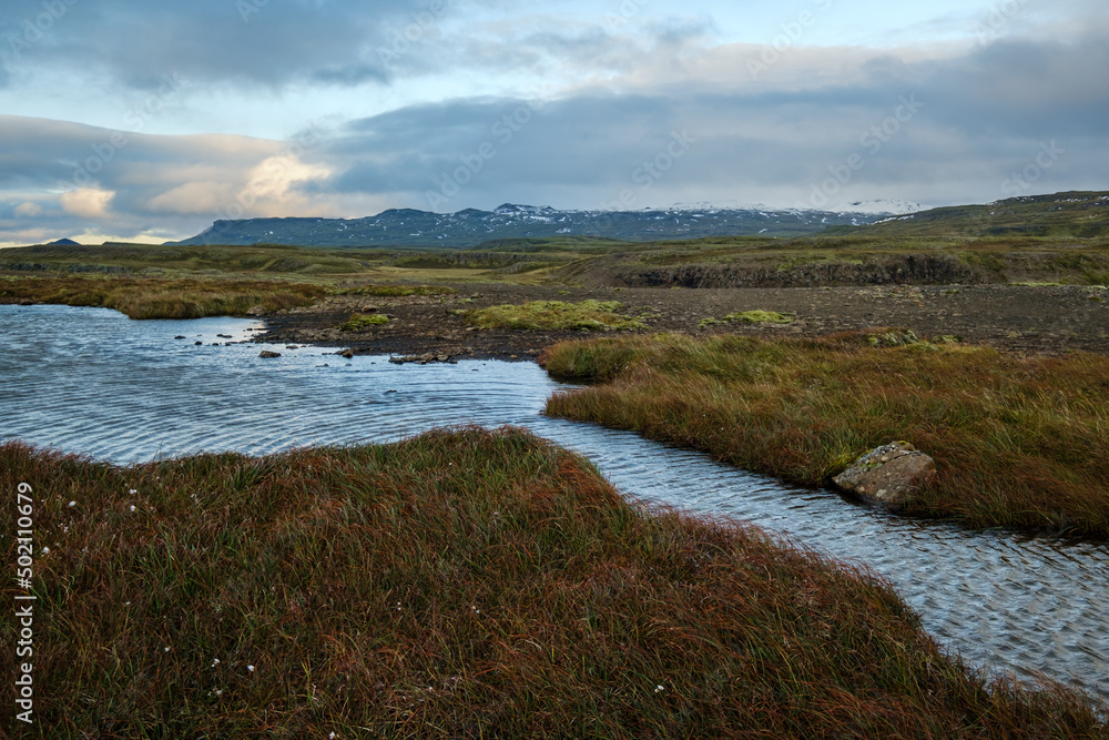 View during auto trip in West Iceland highlands, Snaefellsnes peninsula, Snaefellsjokull National Park. Spectacular volcanic tundra landscape with mountains, craters, lakes, gravel roads.