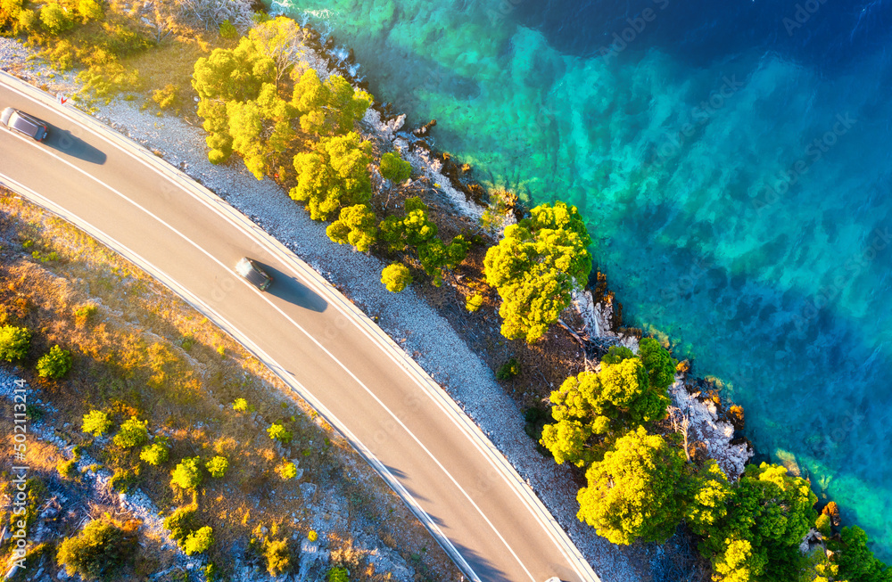 View of the road along the coast from the drone. Travel by car in summer time. The sea coast and the road. The coast of Europe.