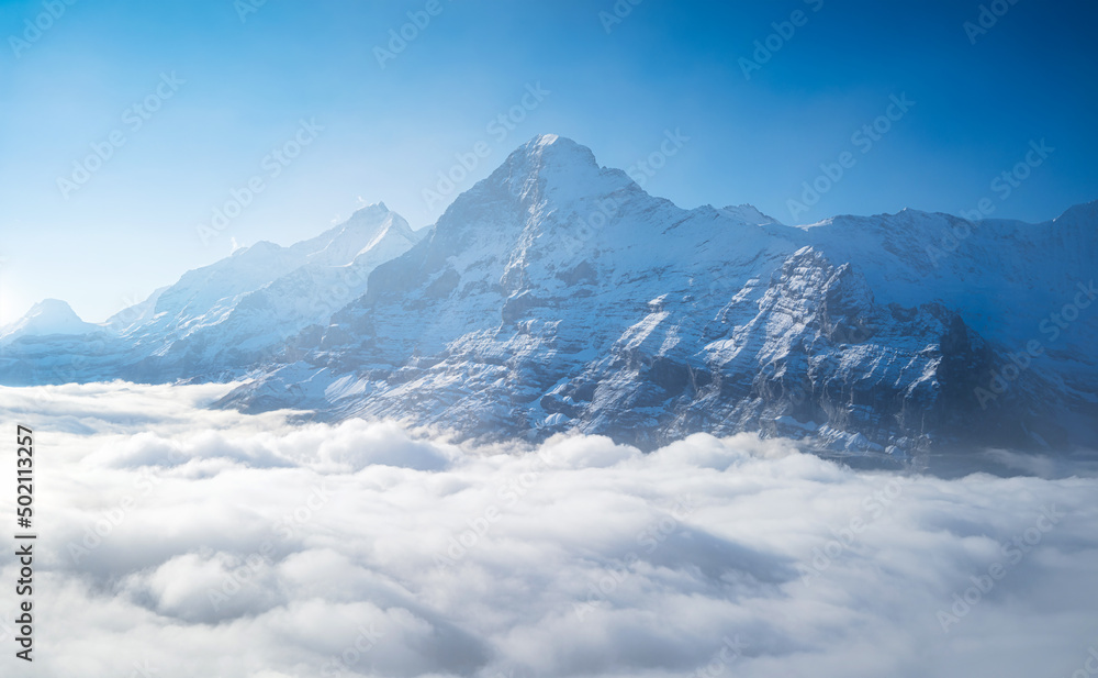 Mountains peaks and clouds in the valley. Natural landscape. Mountain range through the clouds. Landscape in the summertime.