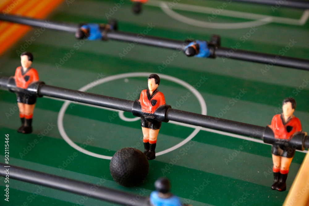 Fototapeta premium Foosball. Soccer hall game. Traditional game. Soccer game. Table with soccer players. Old wooden foosball. Football players. Dolls with blue and red painted T-shirts. Metegol