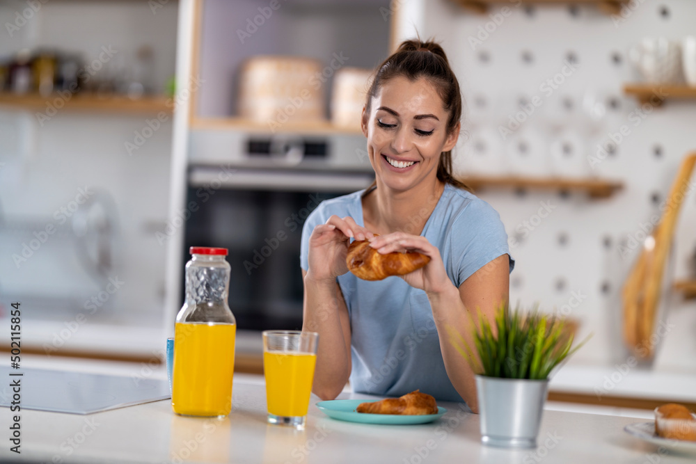 Smiling young woman having breakfast at home Smiling young woman having breakfast at home
