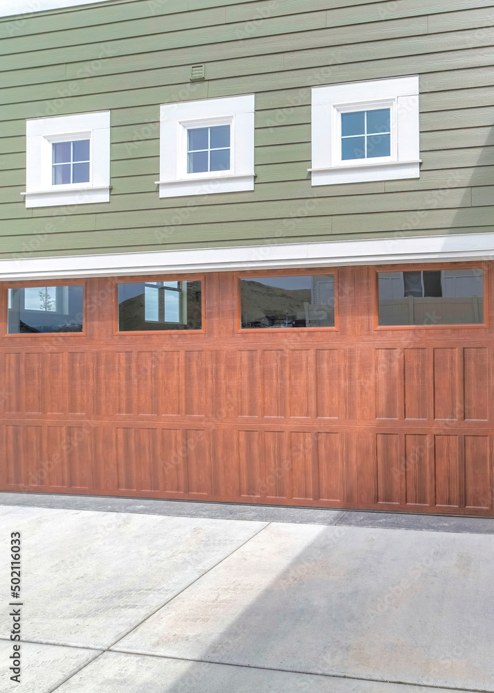 Vertical Wooden garage doors with window panels and wall lamp Vertical Wooden garage doors with window panels and wall lamp