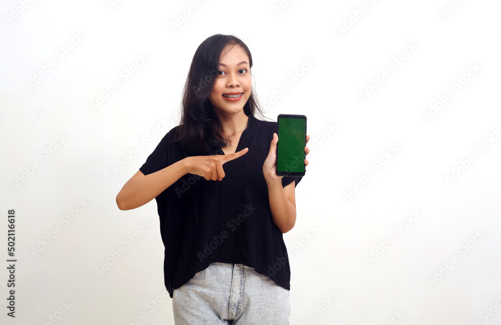 Asian young woman pointing a blank screen of her cell phone. Isolated on white background Asian young woman pointing a blank screen of her cell phone. Isolated on white background